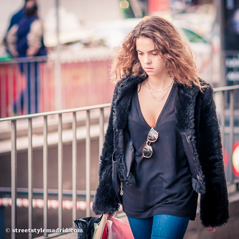 Street Style Madrid, cazadora de pelo, gafas de sol, camiseta negra y vaqueros.