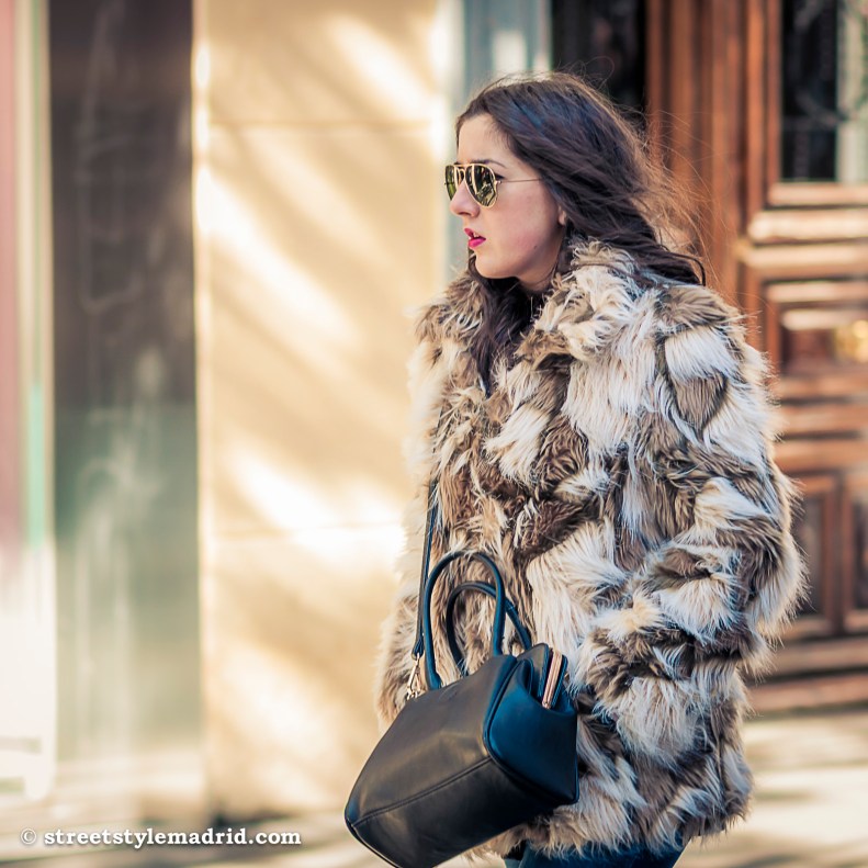 Street Style Madrid, abrigo de pelo, blanco y marrón, con bolso negro y gafas ray ban aviator.